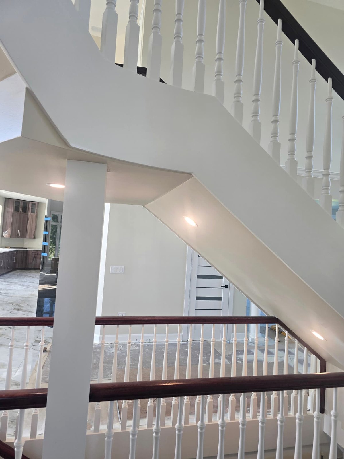 Stair soffit downlights in a finished two-storey entry