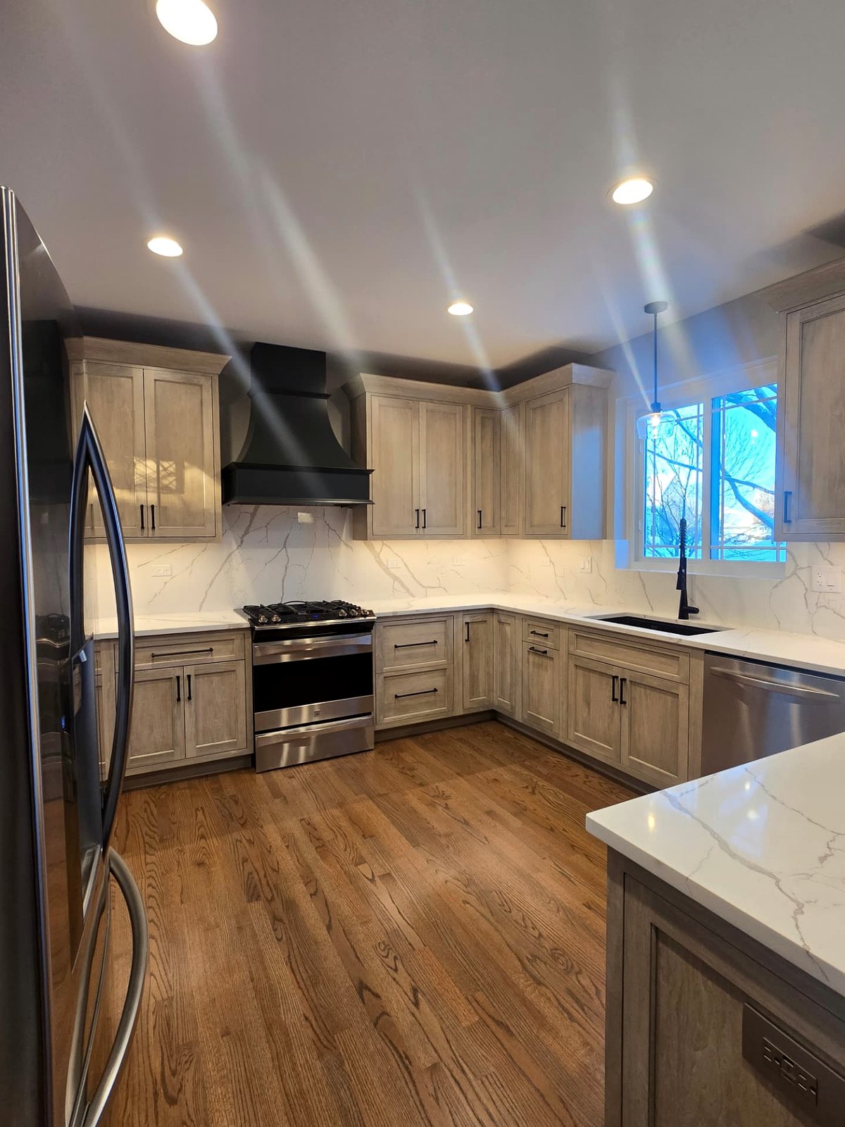 Residential kitchen with recessed and pendant lighting energized