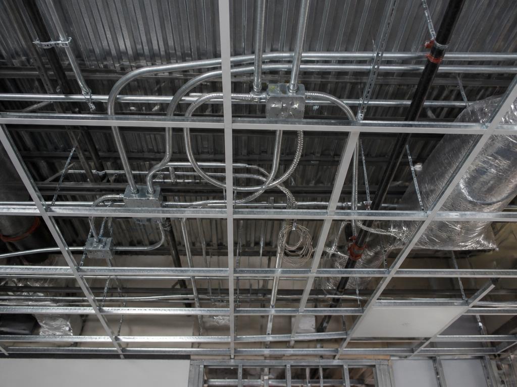 Overhead electrical rough-in of conduit and boxes coordinated above an office ceiling grid